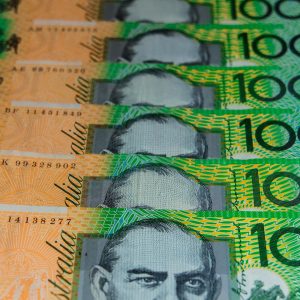 Vertical close-up of stacked Australian 100-dollar banknotes showcasing currency details.