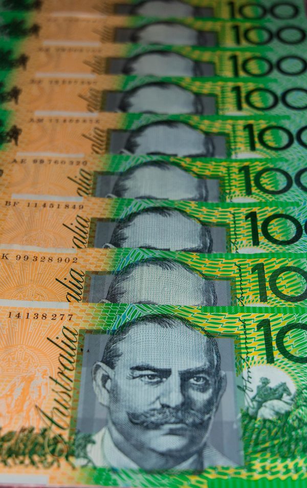 Vertical close-up of stacked Australian 100-dollar banknotes showcasing currency details.